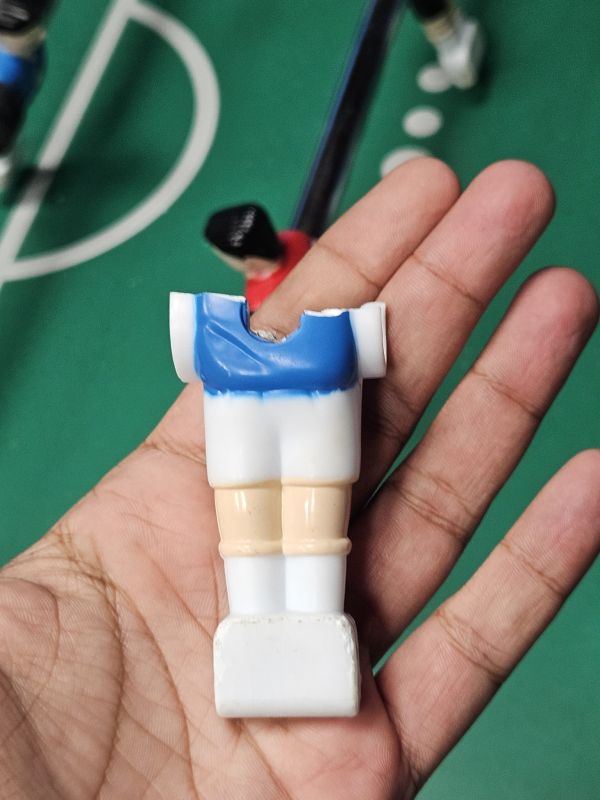 Figurine en plastique cassée dans une main